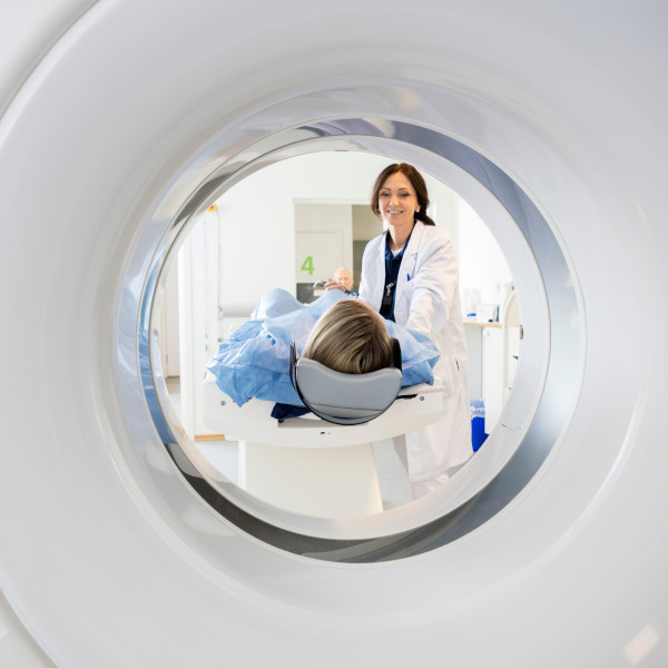 Female patient starting an MRI with female doctor smiling in background