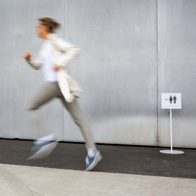 A woman in a hurry running to a bathroom 