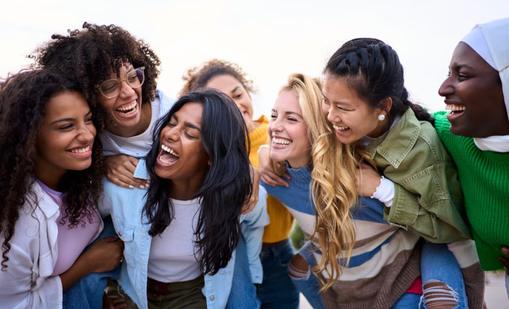 A group of women smiling and laughing, enjoying the moment, together