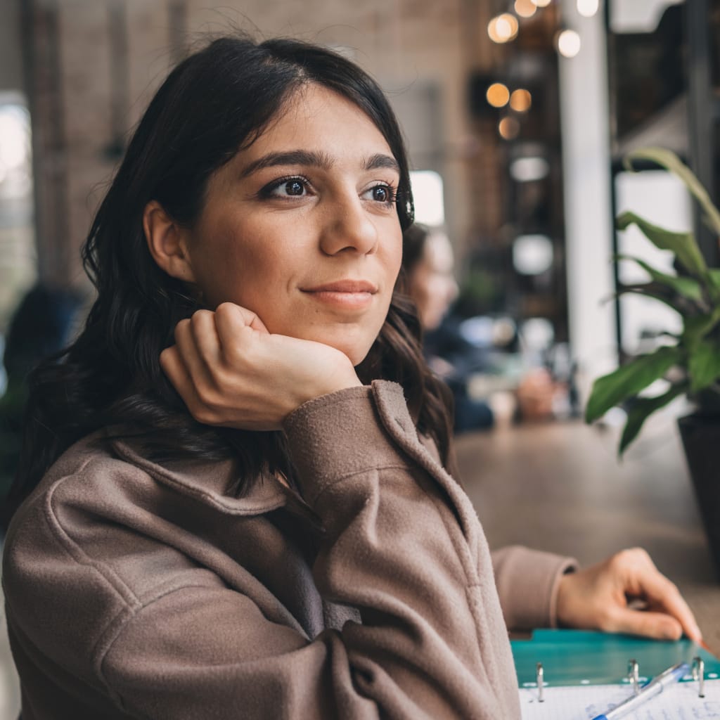 A woman looking off into the distance, in contemplation but with a hopeful gaze.